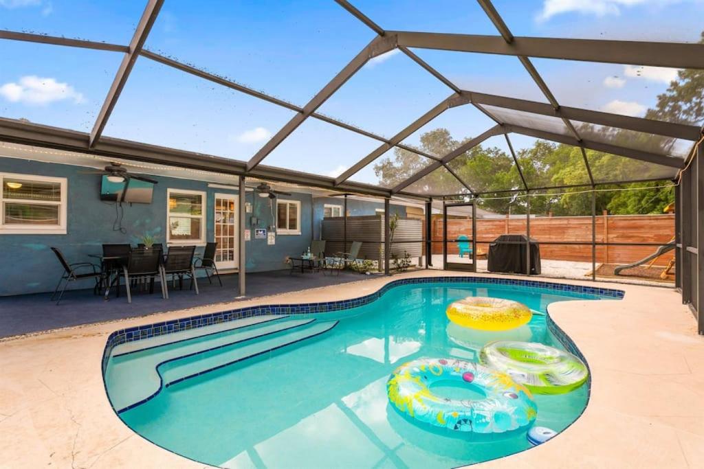 una piscina con pérgola y una casa en Tropical Oasis FL Largo, en Largo