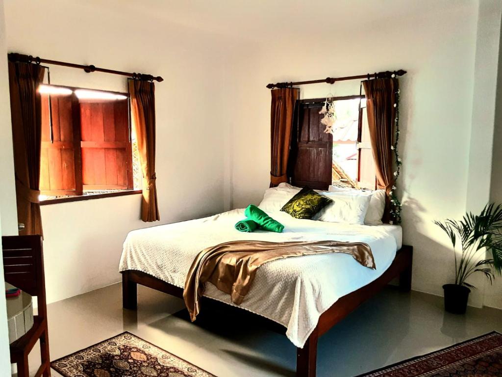 1 dormitorio con 1 cama con cinturón verde en Central Essence en Haad Chao Phao