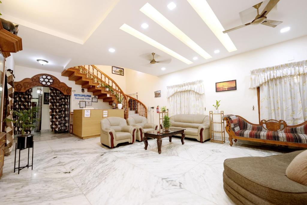 a lobby with couches and chairs and a staircase at Metropolitan Serviced Villa in Cochin