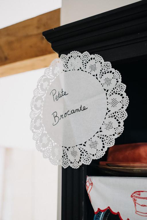 a round white doily on top of a black cabinet at Les Granges Pelloquin in Bernières-sur-Mer