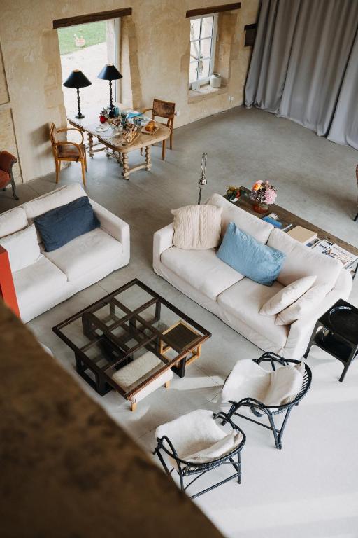 an overhead view of a living room with couches and chairs at Les Granges Pelloquin in Bernières-sur-Mer