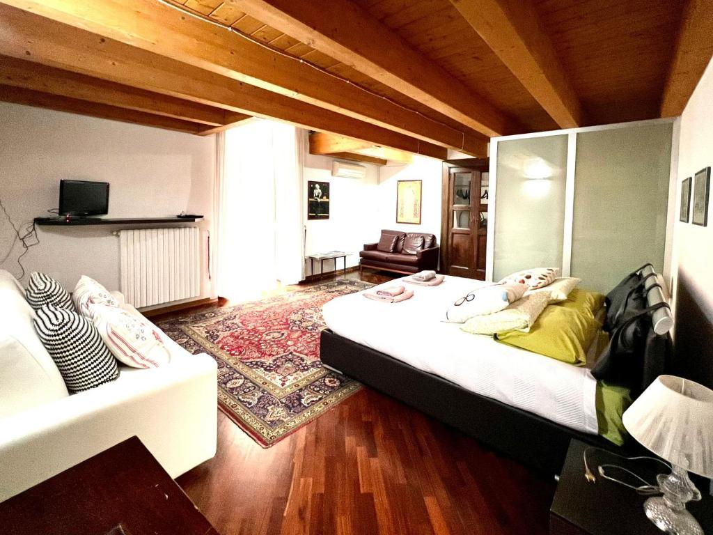 Habitación con 2 camas y sofá. en Saint patrick guest house, en Barletta