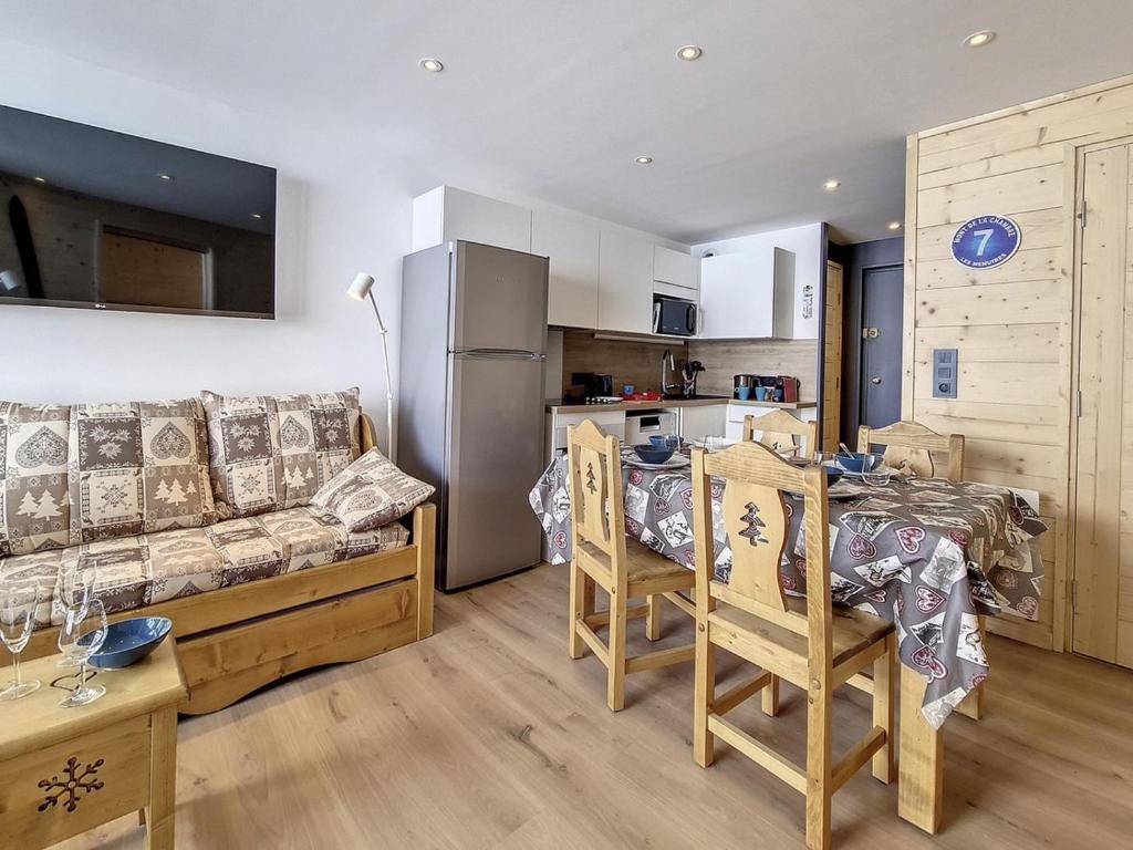 un salon avec un canapé et une table et une cuisine dans l'établissement Charmant appartement rénové - Au pied des pistes - 4 pers - Parking - WiFi - Balcon Sud-Est - FR-1-344-871, aux Menuires