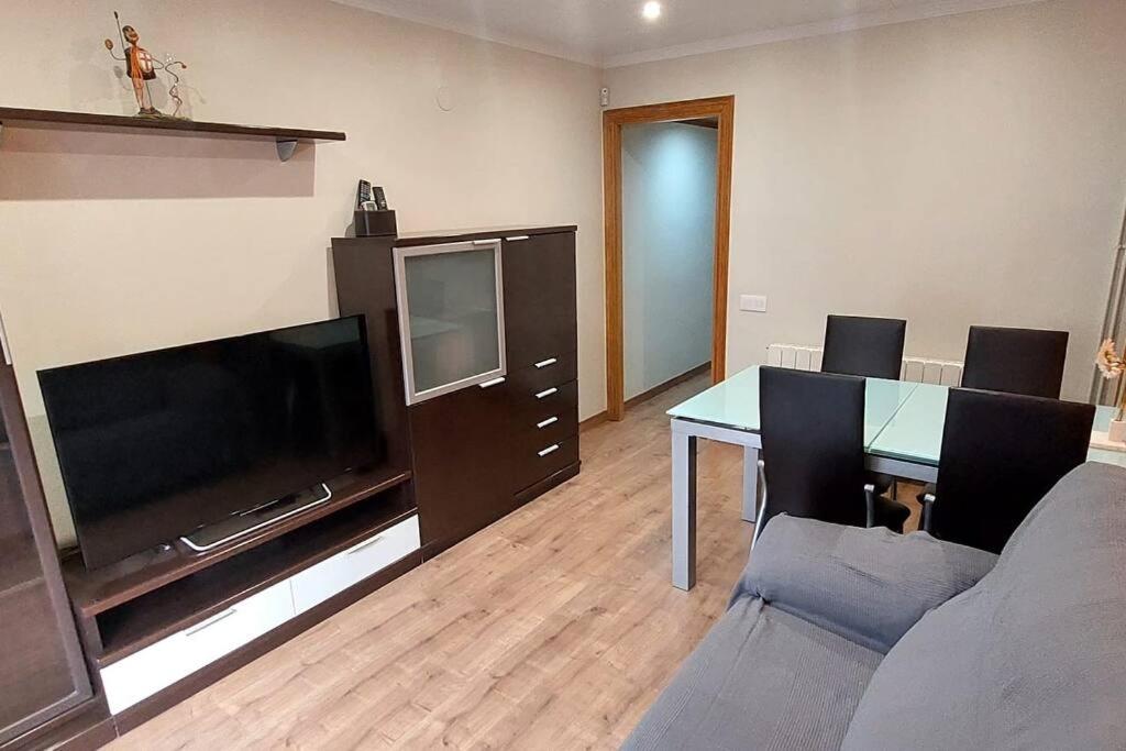 sala de estar con escritorio, TV y sofá en Bravaholidays-831-Fabra-Barcelona, en Santa Coloma de Gramenet