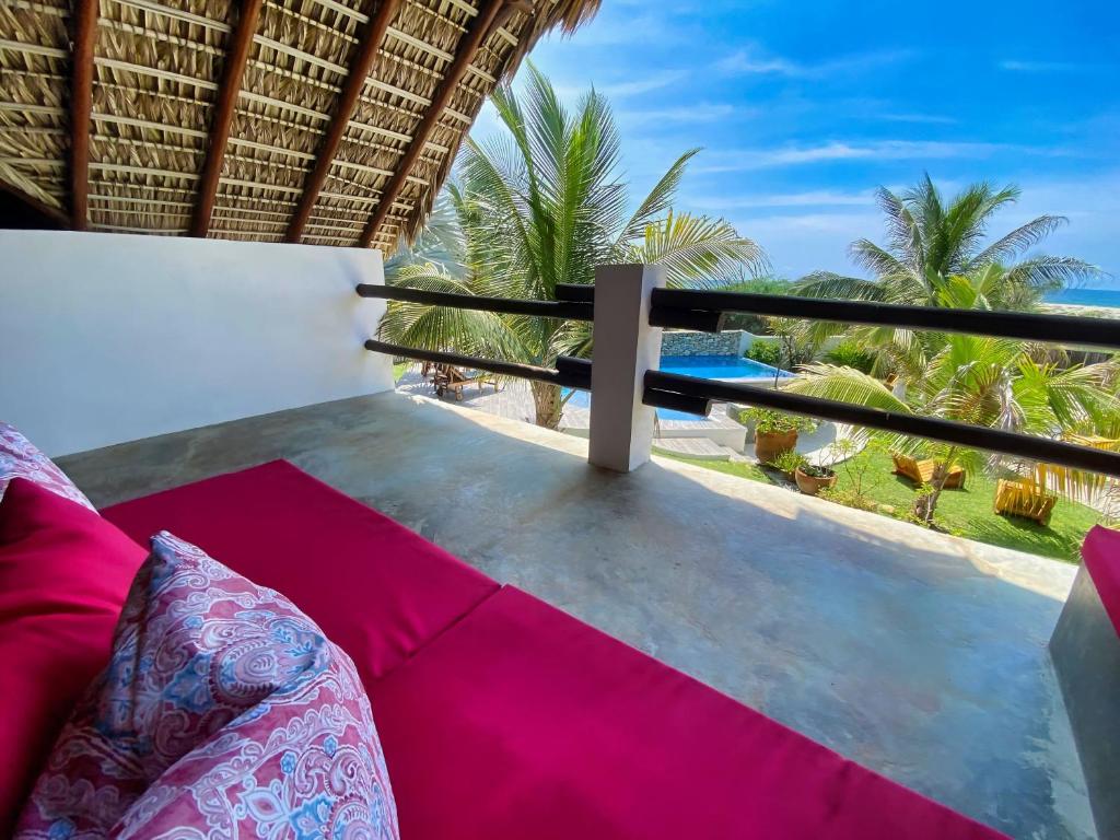 a room with a balcony with a view of the ocean at CasaPiedra in Puerto Escondido