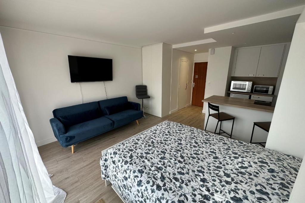 - une chambre avec un lit bleu et un canapé dans l'établissement Perfect studio for a romantic getaway, à La Baule