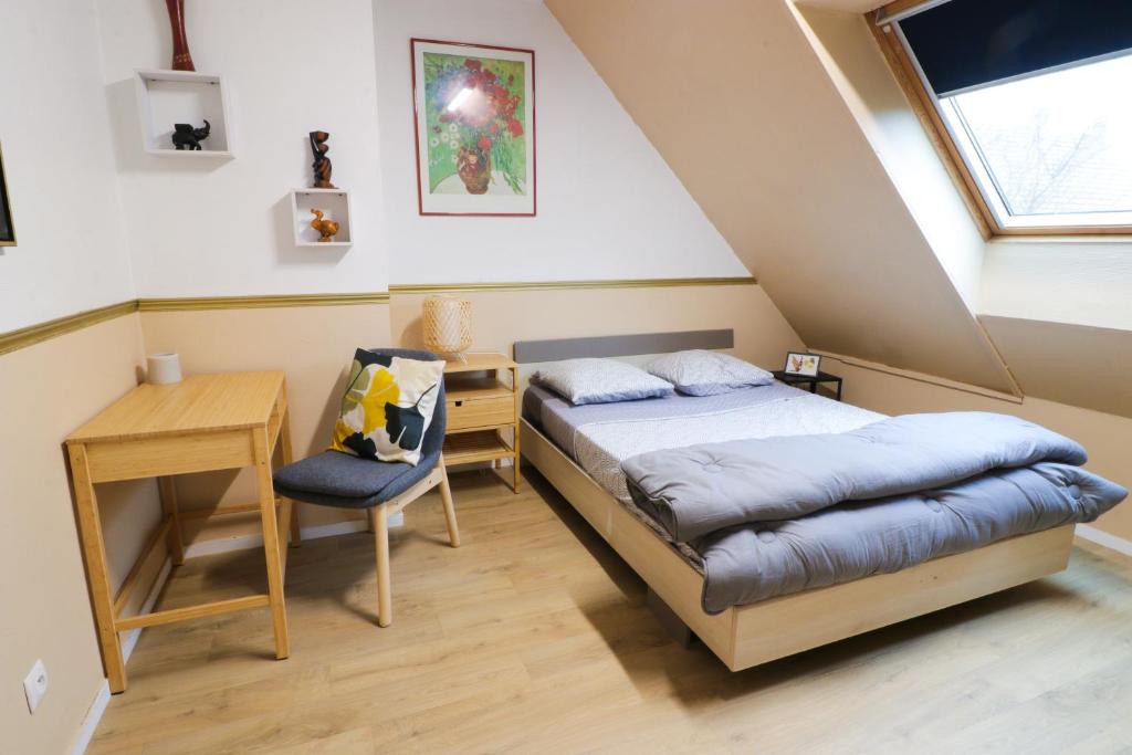 une chambre avec un lit, un bureau et une fenêtre dans l'établissement Nov Sweety Home, à Goussainville