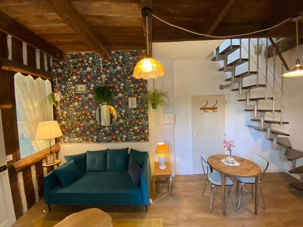 een woonkamer met een blauwe bank en een tafel bij Duplex de charme à Lessy in Lessy