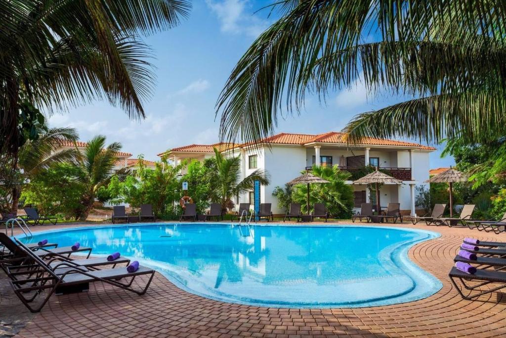 uma piscina em frente a uma casa com palmeiras em Poolside Serenity at Tortuga Beach - 491 em Prainha