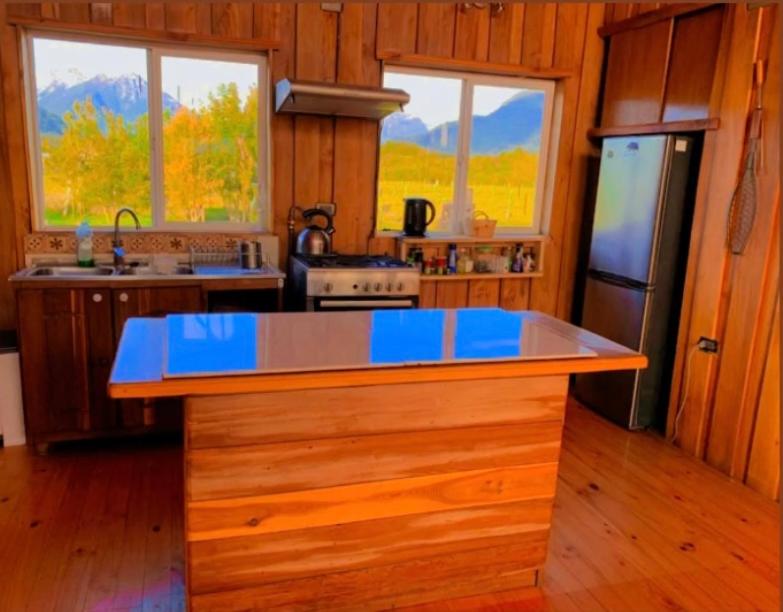 a kitchen with a blue counter top in a cabin at La Ruka Negra in Puelo