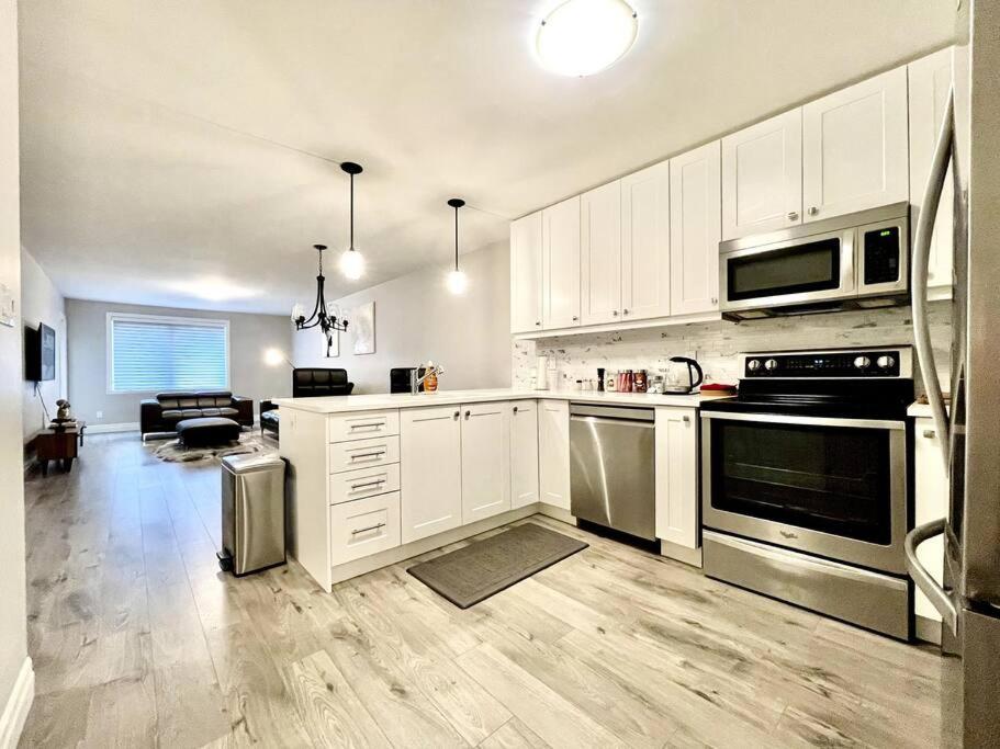 a kitchen with white cabinets and stainless steel appliances at Hillside Villa - Trenton in Trenton