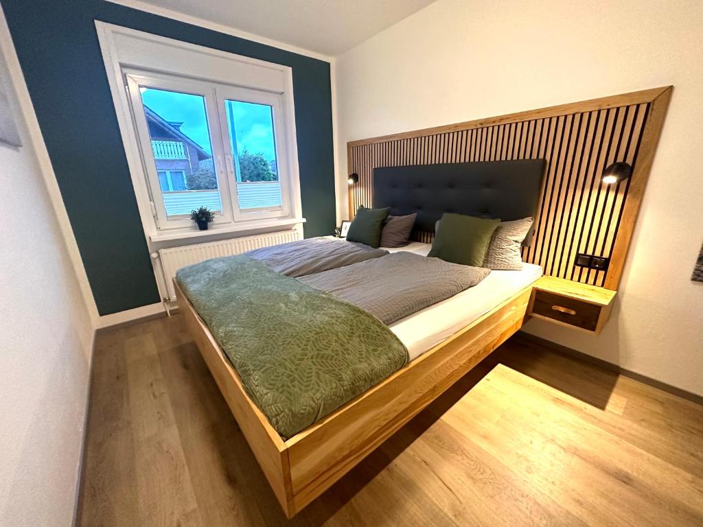 a bedroom with a large bed and a window at Auszeit Norddeich in Norddeich