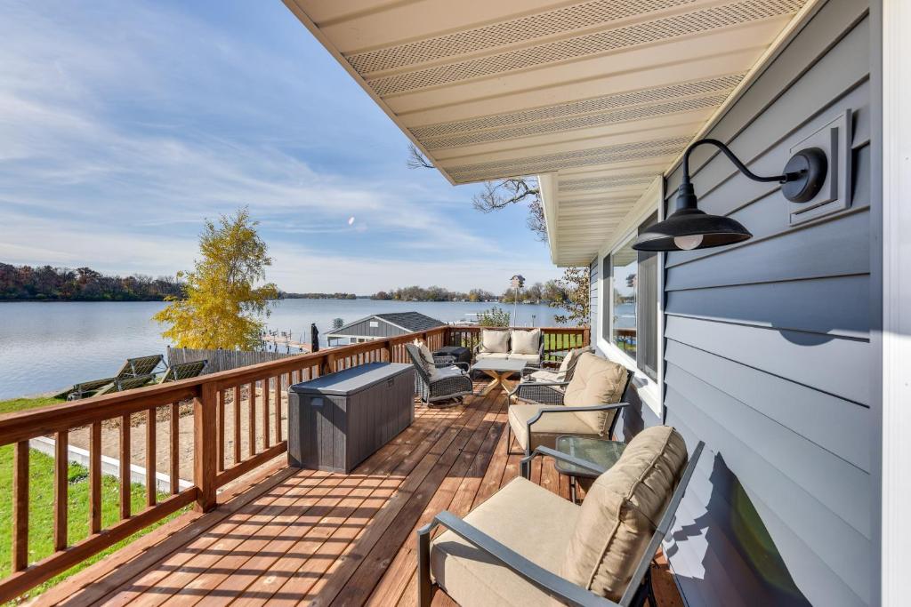 a deck with chairs and a view of the water at Lakefront Fox Lake Home with Furnished Deck! in Fox Lake