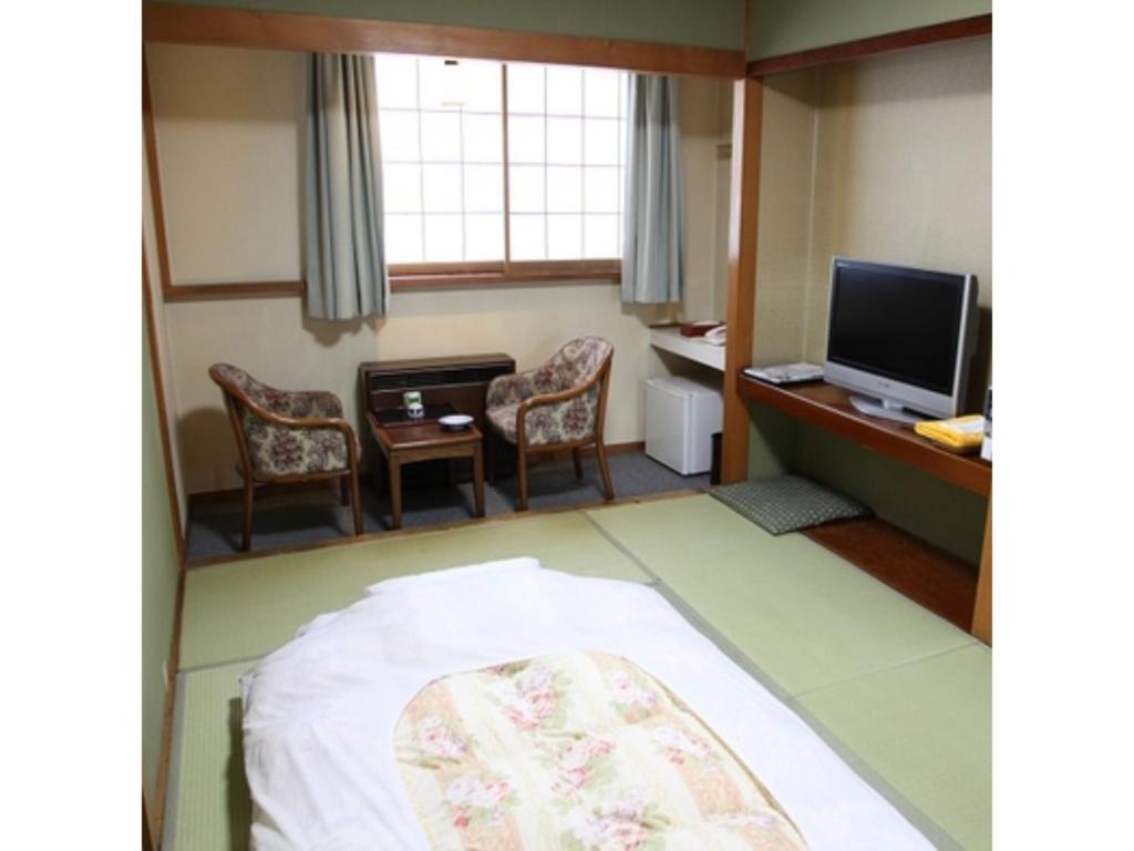 常總市的住宿－Tsukuba Town Hotel - Vacation STAY 65188v，配有床、椅子和电视的房间