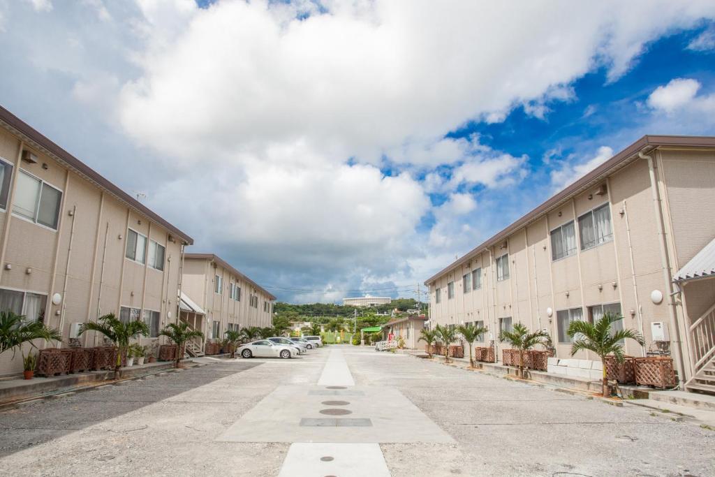 a street in an apartment complex with a car parked at Southern Village Okinawa in Kitanakagusuku