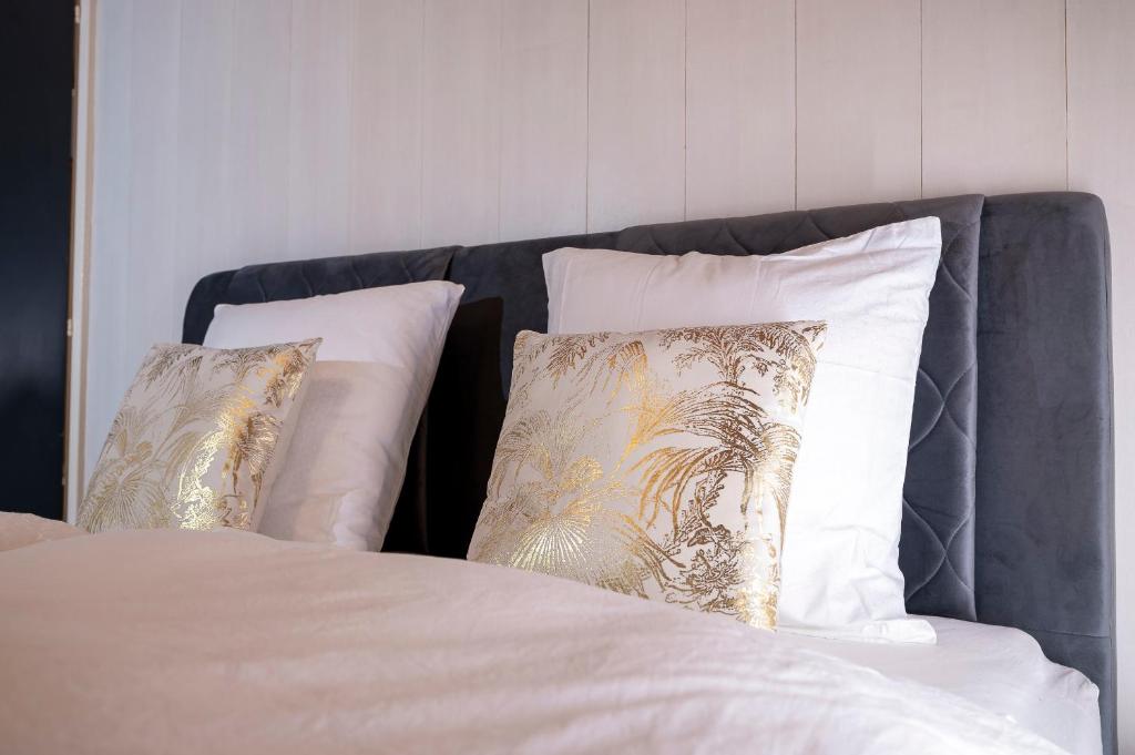 un letto con lenzuola e cuscini bianchi di Glishorn Blick a Brig