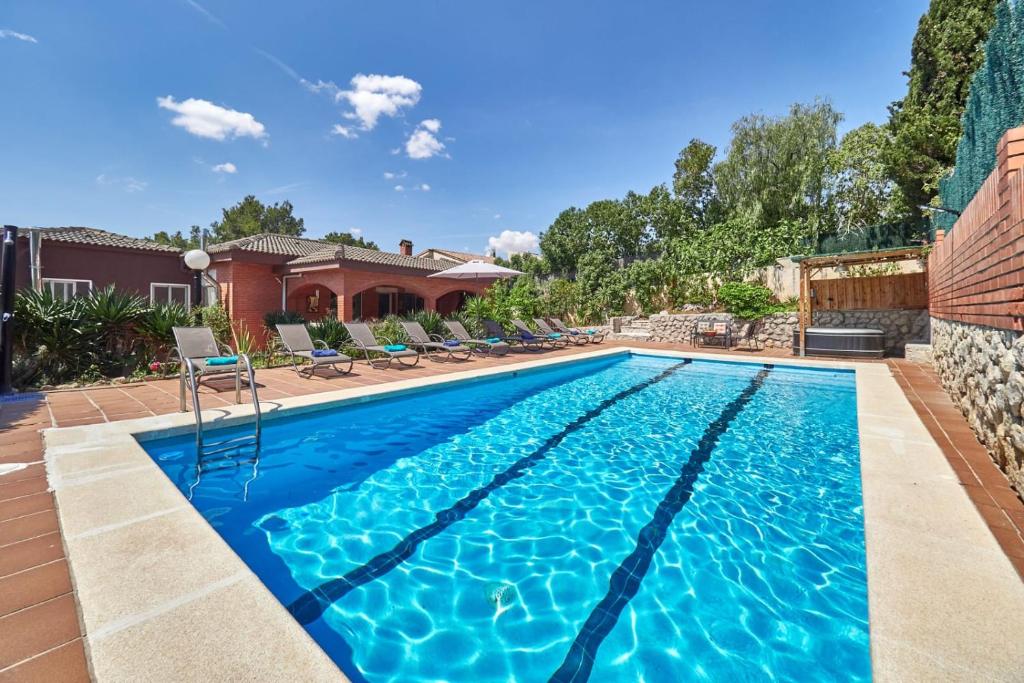a swimming pool with blue water in a yard at Villa Soledad en Olivella, Sitges, Barcelona in Olivella