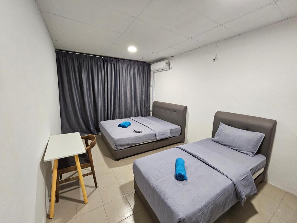 a room with two beds and a table and a chair at SS HOSTEL PENANG in George Town