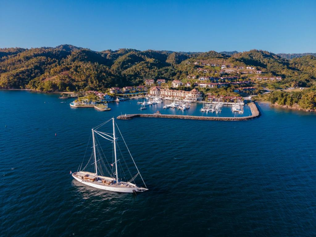 una barca a vela in acqua di fronte a un porto di The Bannister Hotel & Yacht Club by Mint a Santa Bárbara de Samaná