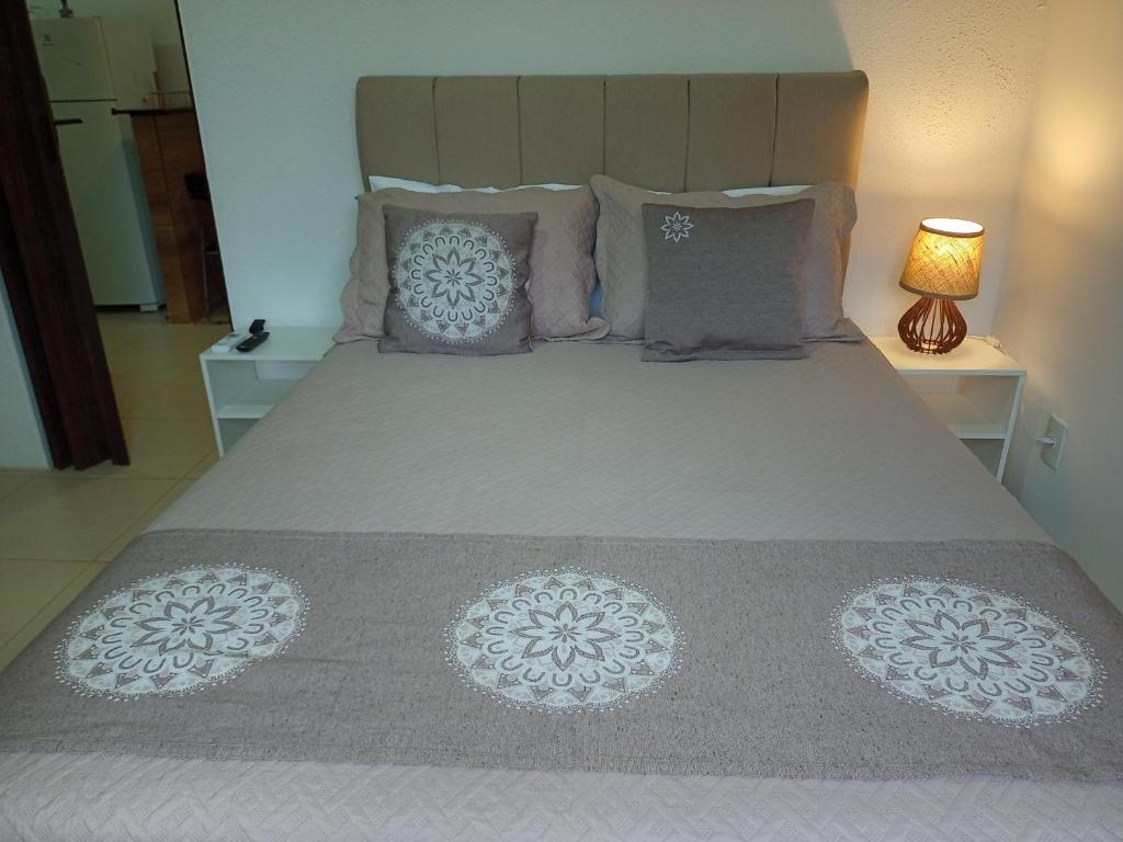a bedroom with a large bed with pillows at Flats Casa Verde in Saquarema