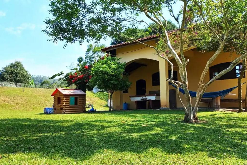 a house with a tree and a dog house at Sítio São Francisco Capacidade 30 Pessoas Juquitiba SP in Juquitiba