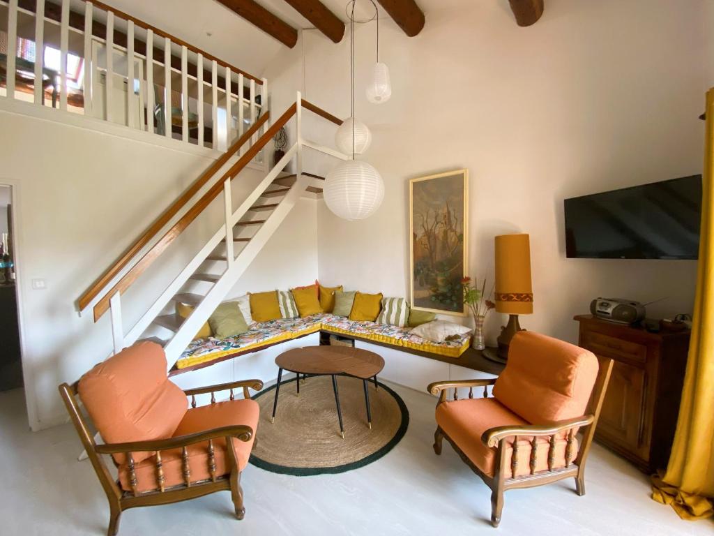 - un salon avec un escalier, un canapé et des chaises dans l'établissement T3 rénové à 8 min de la mer, à Saint-Cyr-sur-Mer