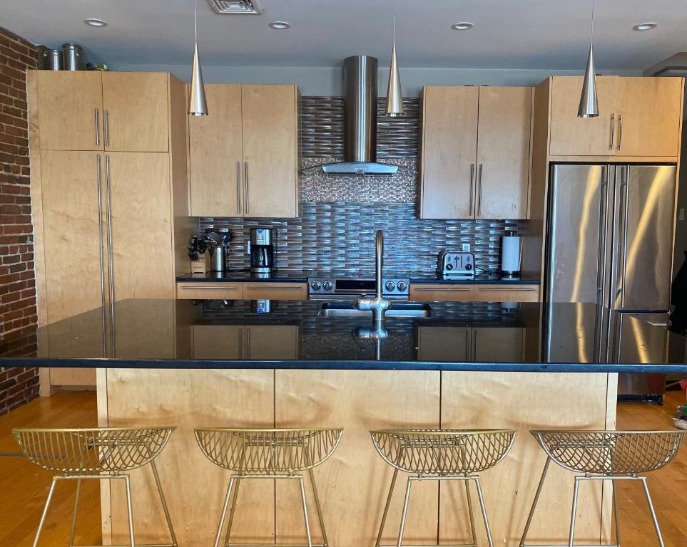 a kitchen with a counter with chairs and a refrigerator at Boston North end Harbor View condo. FREE PARKING in Boston