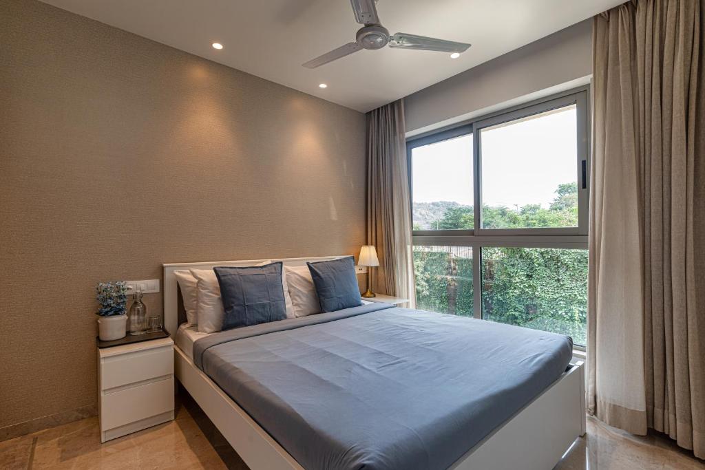 ムンバイにあるEntire One Bedroom Apartment - Hiranandani Gardens, Mumbai Powaiのベッドと大きな窓のある寝室
