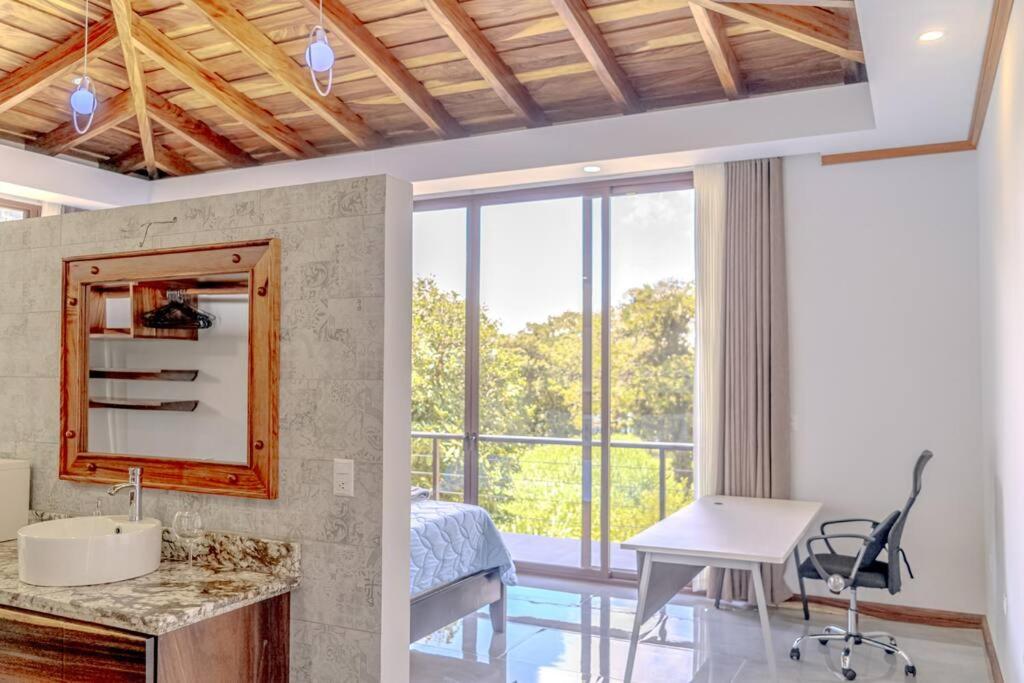 ein Schlafzimmer mit einem Schreibtisch, einem Tisch und einem Spiegel in der Unterkunft Cloud Forest House Monteverdes in Monteverde Costa Rica