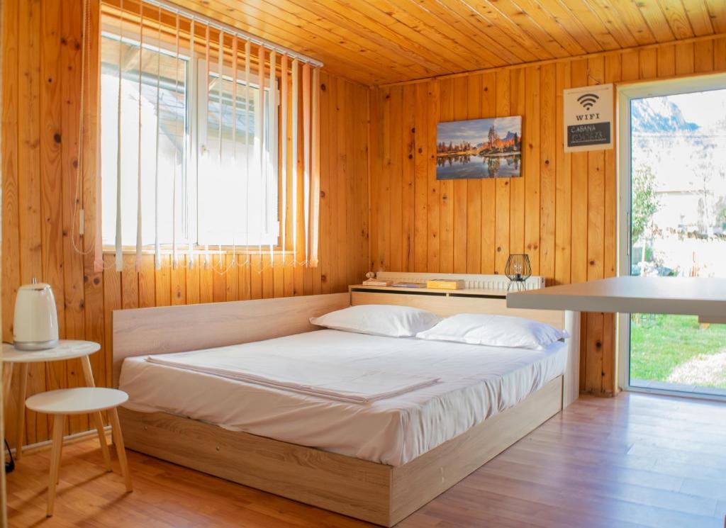 um quarto com uma cama num quarto de madeira em Mountain VISTA, Bușteni em Buşteni