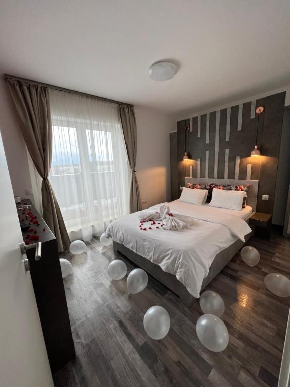 sypialnia z dużym łóżkiem z białymi kulami na podłodze w obiekcie MONCLER RESIDENCE w Braszowie