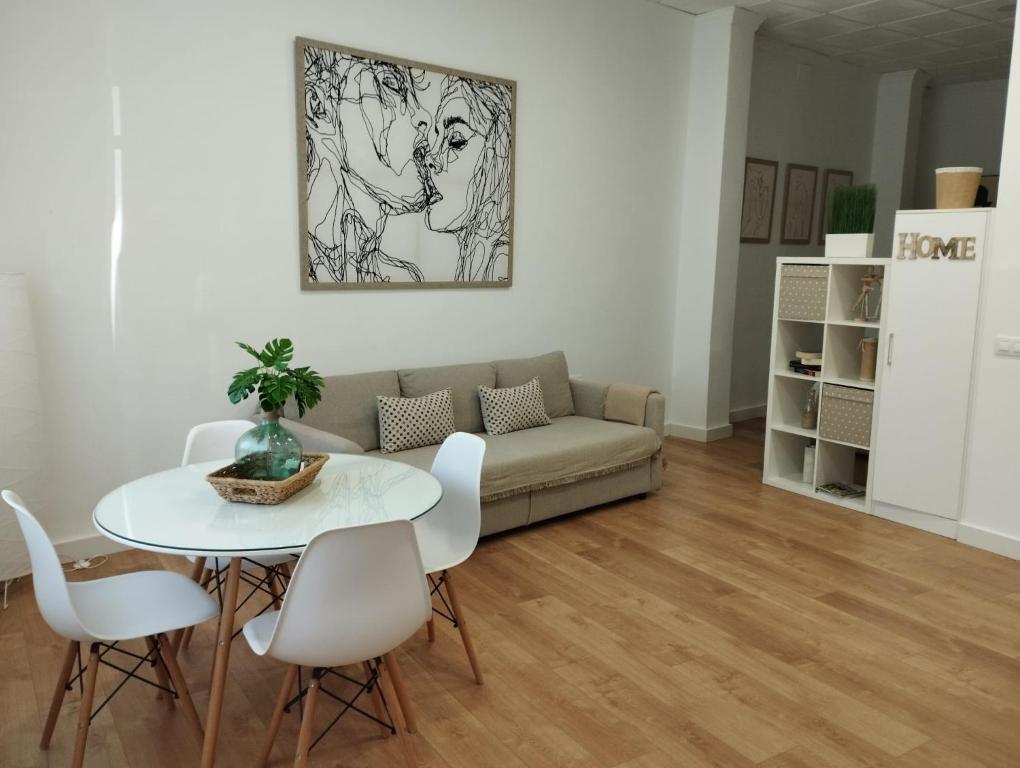 a living room with a couch and a table and chairs at APARTAMENTO TURISTICO LEO BAENA in Baena