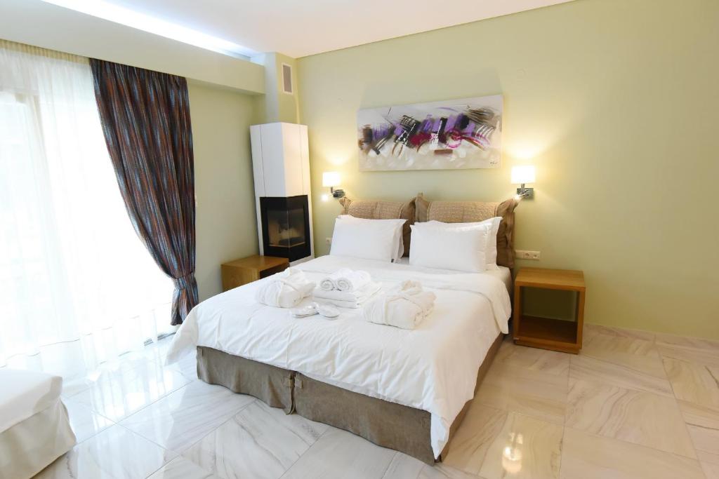 a bedroom with a large bed with towels on it at Edem Luxury Apartments in Nea Peramos