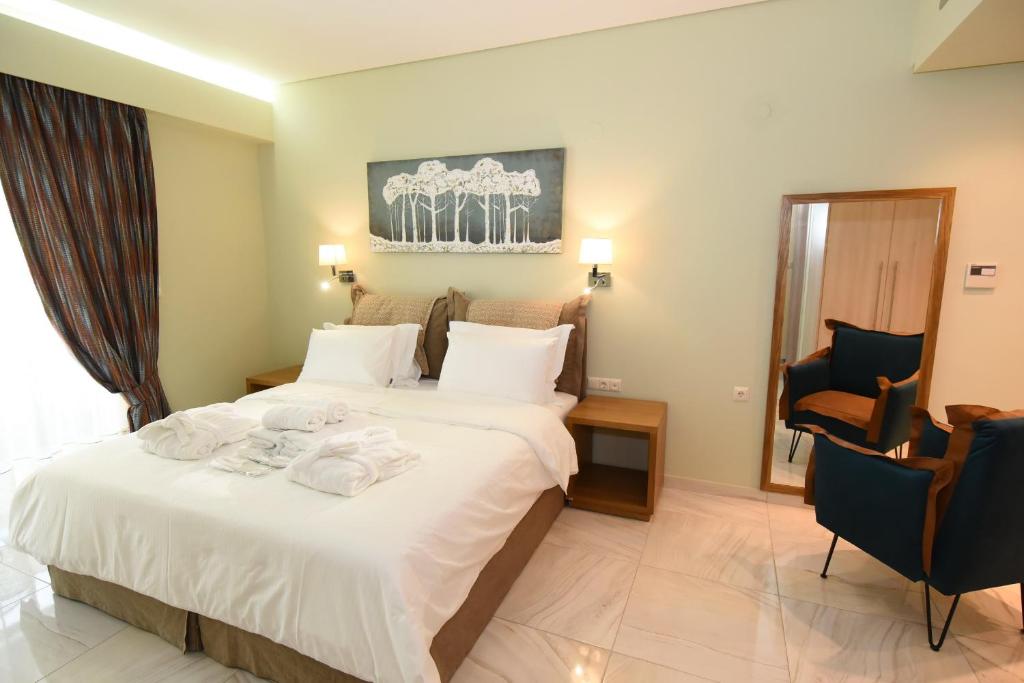 a hotel room with a bed with towels on it at Edem Luxury Apartments in Nea Peramos