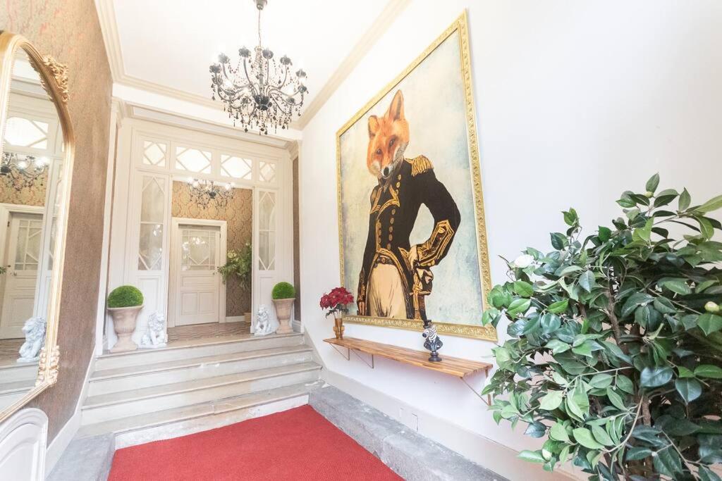 un couloir avec un tapis rouge et une peinture sur le mur dans l'établissement Immeuble L'aristocrate - Le Nuage - Bd Carnot, à Angers