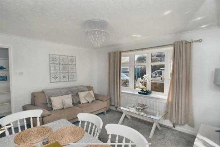 sala de estar con sofá, mesa y sillas en Hideaway Whitstable en Kent
