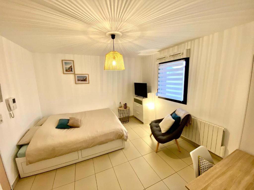 a bedroom with a bed and a table and a chair at Le Cocon des Thermes Amneville Metz Luxembourg in Amnéville