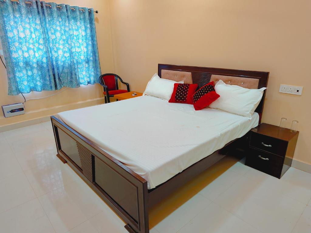 een bed met twee rode kussens op een kamer bij Saryu Lodge near Ram Janam Bhumi in Ayodhya