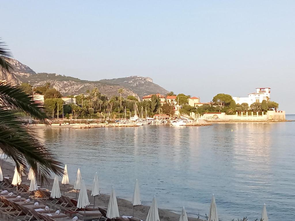 Ein Strand mit einem Haufen Regenschirme auf dem Wasser in der Unterkunft Voilier tout confort in Beaulieu-sur-Mer