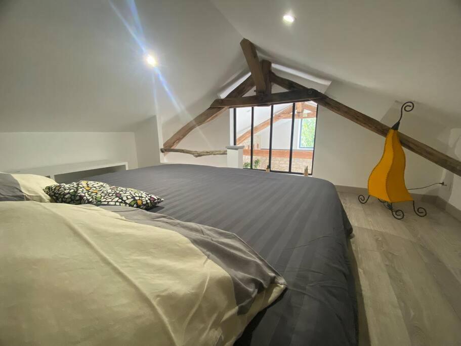 a bedroom with a large bed in a attic at Maison de charme - proche Futuroscope in Montamisé