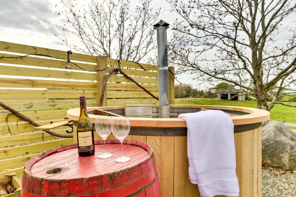 a bottle of wine and two glasses on a barrel at Unique Stay Finger Lakes Converted Horse Barn in Rushville