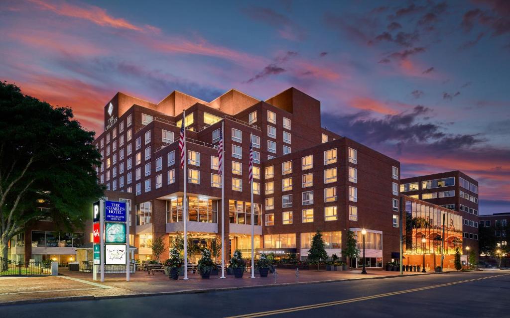 a building on a city street with a sunset at The Charles Hotel in Harvard Square in Cambridge