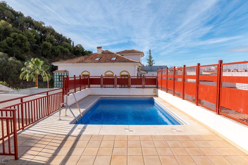 a house with a swimming pool and a fence at Estudio Céntrico Agua Gibralfaro con Piscina in Málaga