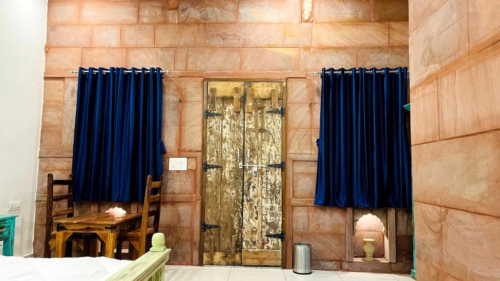 une pièce avec des rideaux bleus et une porte vitrée dans l'établissement Geel Heritage - A Restored Haveli, à Jodhpur