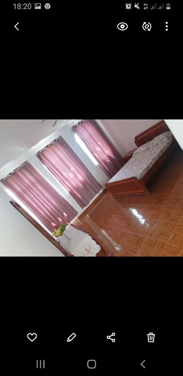 una imagen de una habitación con una ventana con cortinas rosas en Residencial/ Pensão Natur en Tarrafal