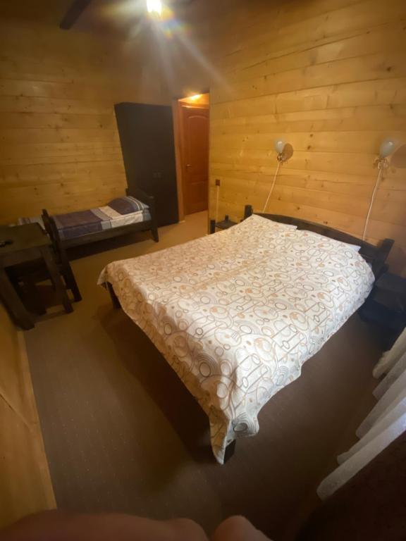a bedroom with a bed in a wooden room at Highland in Yablunytsya