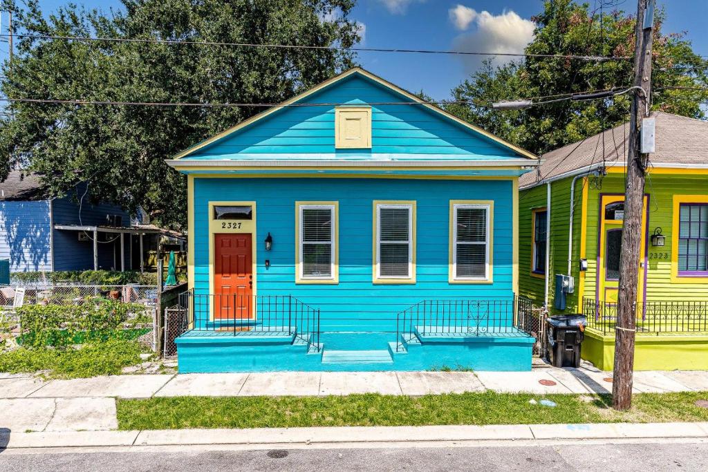 una casa azul y amarilla con una puerta roja en Revived Nola Home Near Everything!, en Nueva Orleans