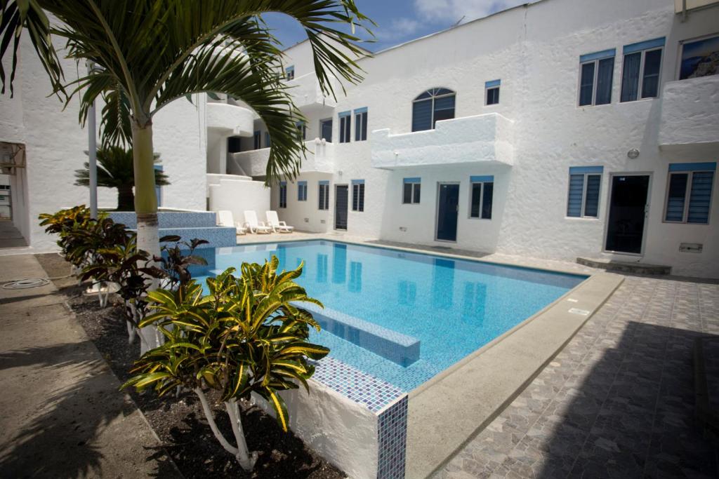 una piscina frente a un edificio blanco en COMODO DEPARTAMENTO CERCA DE LA PLAYA WIFFI en Tonsupa