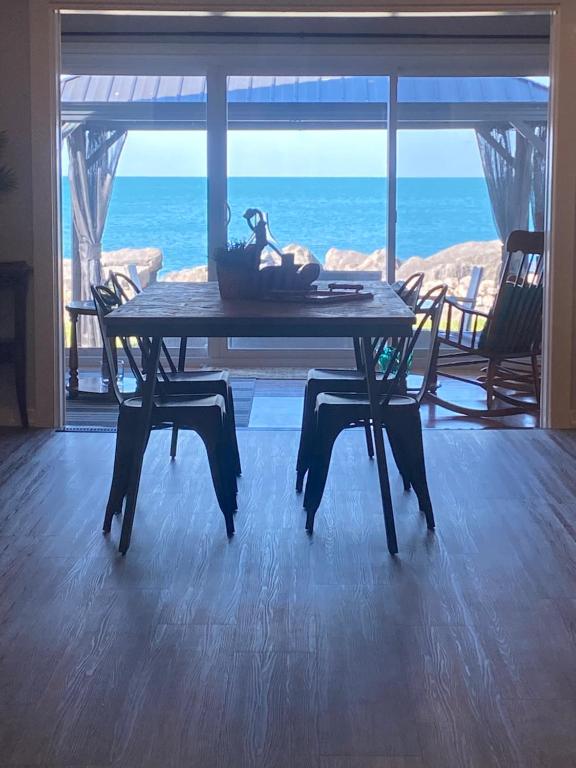 a dining room table with a view of the ocean at Casa Azul-lakefront in Leamington