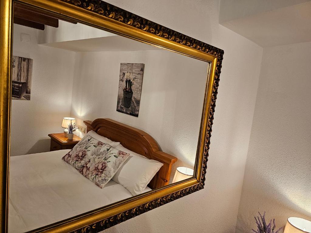 espejo que refleja una cama en un dormitorio en Casa Turistica Torreón de Villafamés en Villafamés